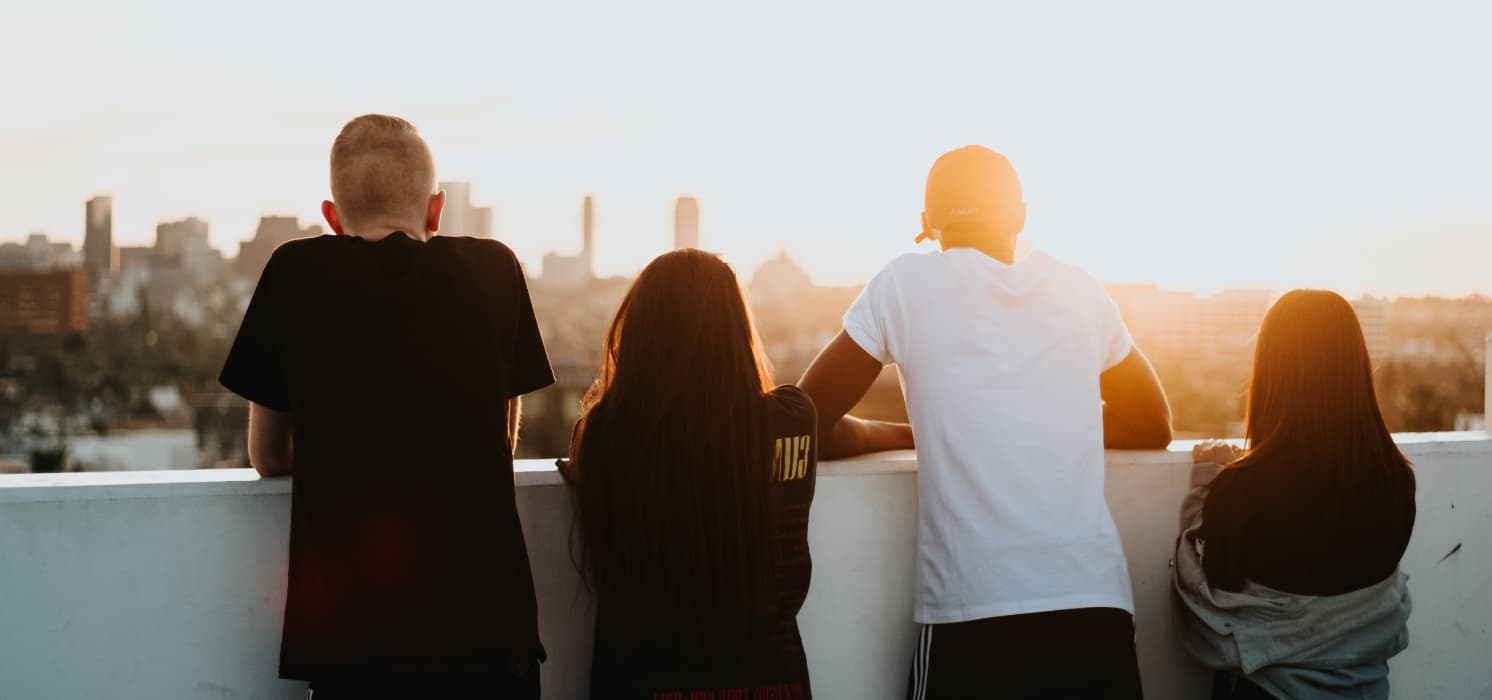 a group of young people looking at the sunset